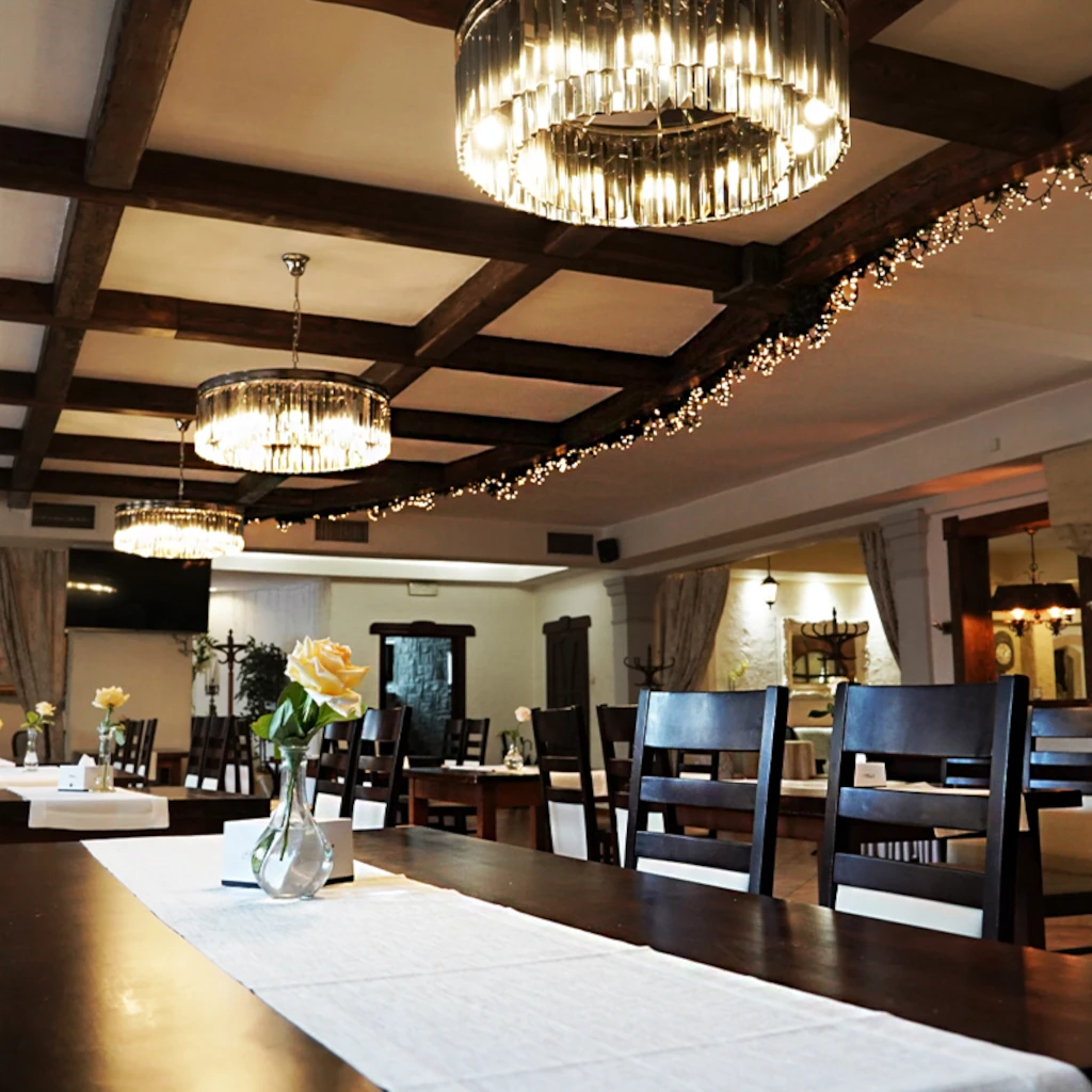 wnętrze restauracji maraton w Bydgoszczy. Okrągłe żyrandole nad długimi, brązowymi stołami.